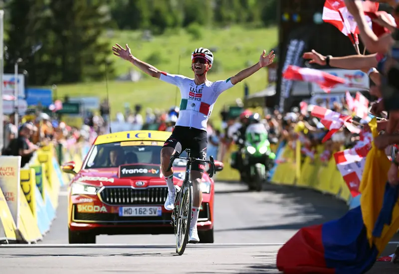 El ciclista mexicano Isaac del Toro celebra su victoria al ganar la etapa final del Tour Auvergne-Rhône-Alpes 2026 en los Alpes.