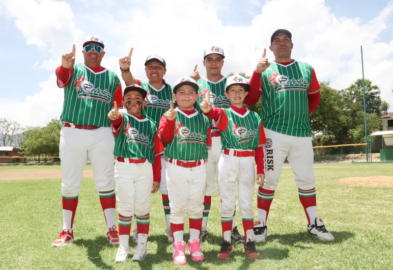 Jóvenes beisbolistas de la Liga Petrolera posan sonrientes junto a sus entrenadores tras coronarse campeones en la final del torneo Regional Pre Moyote.