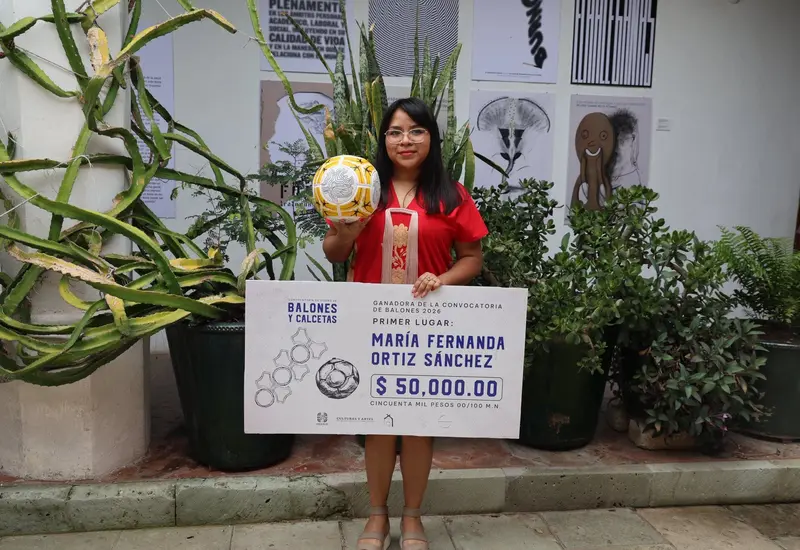 María Fernanda Ortiz Sánchez, ganadora del primer lugar en el concurso 'Balones y Calcetas', posa junto a su obra 'Vínculo y territorio'.
