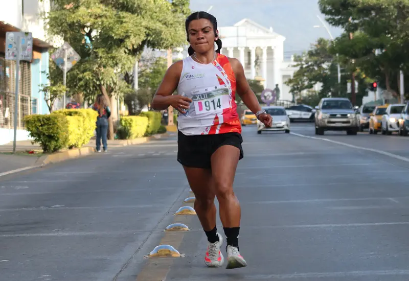 La atleta Solecito Hdz compite con determinación durante un tradicional medio maratón, demostrando la fuerza y libertad que le da el deporte.