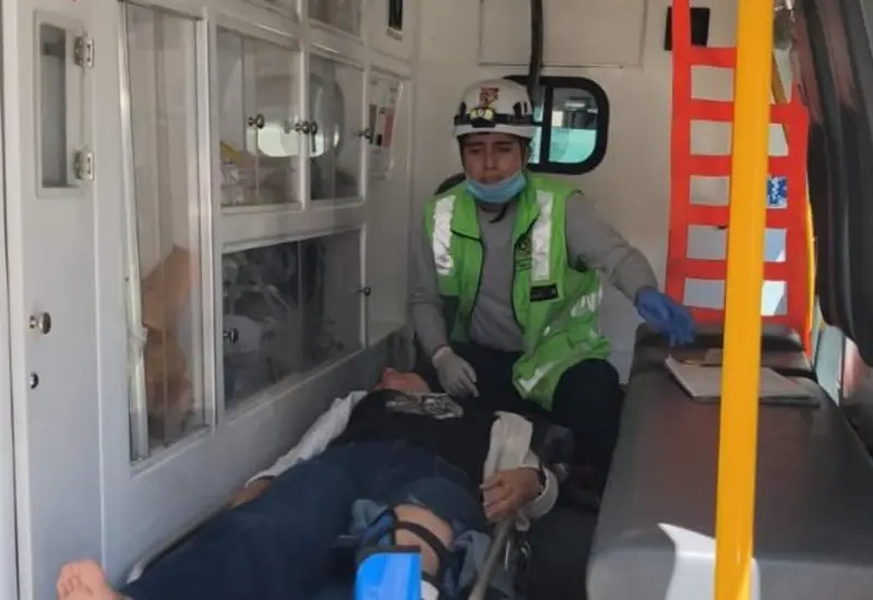 La mujer que resultó lesionada tras un accidente de motocicleta es trasladada en una camilla por paramédicos para recibir atención hospitalaria.