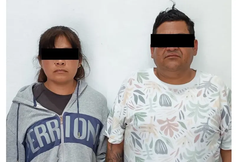 Una pareja es fotografiada después de ser detenida por las autoridades al ser sorprendidos intentando vender una motocicleta con reporte de robo.