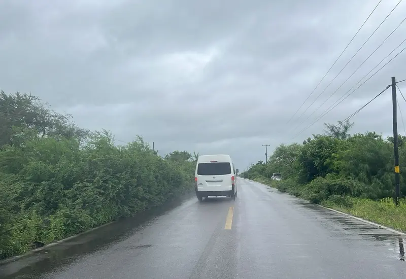 Un vehículo circula con dificultad bajo una lluvia intensa, ilustrando la recomendación de las autoridades de reducir la velocidad en el Istmo de Tehuantepec.