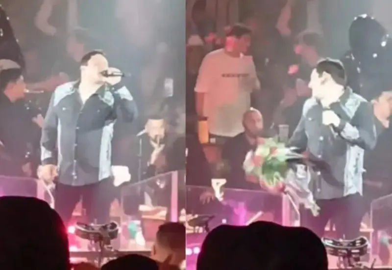 El cantante Julión Álvarez es captado en el momento exacto en que un ramo de flores impacta directamente contra su rostro durante un concierto.
